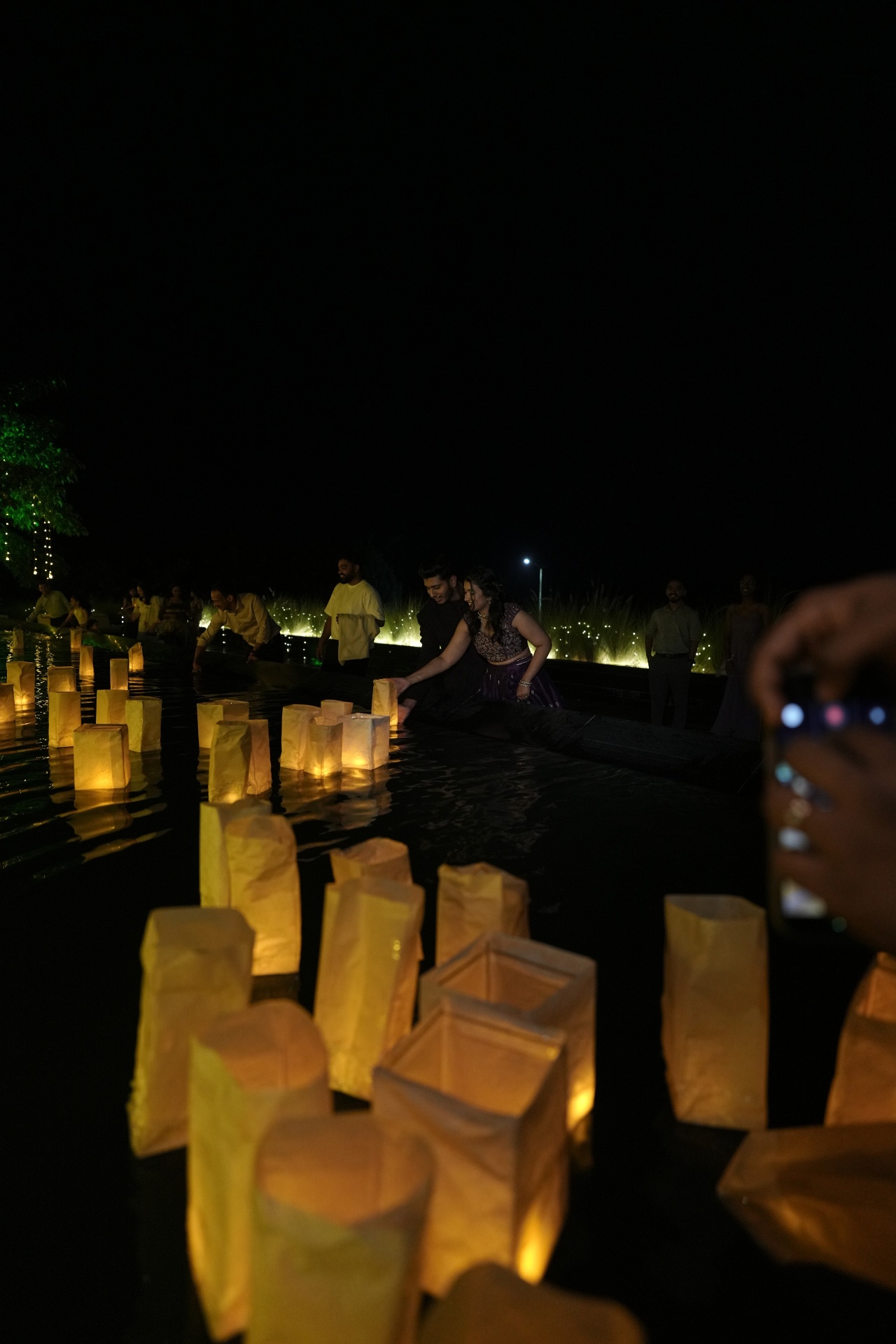 Floating lanterns drifting across the poolside as the celebration's finale
